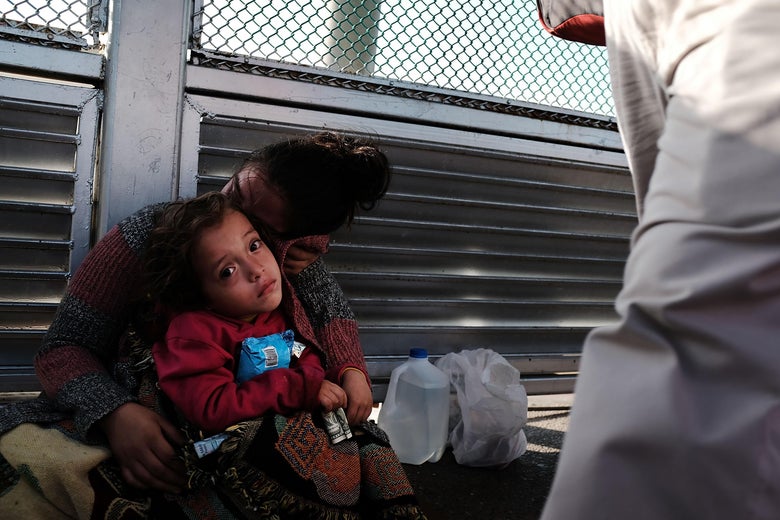 A Honduran child and her mother wait along the border bridge after being denied entry from Mexico into the U.S.